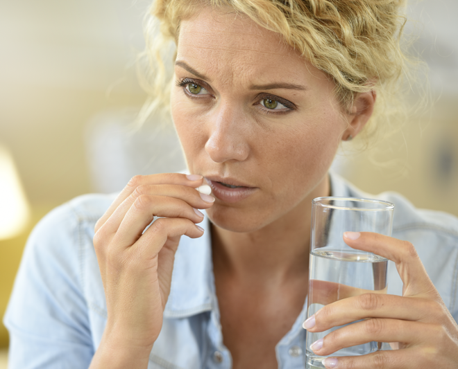 woman taking antibiotic